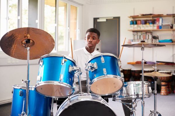 male-teenage-pupil-playing-drums-in-music-lesson-2022-03-30-20-23-47-utc.jpg